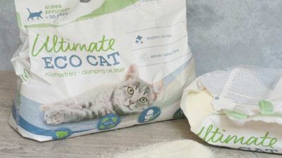 Das Ultimate Eco Cat wird in Papiersäcken geliefert und ist extrem fein und hell Zwei Säcke Ultimate Eco Cat Katzenstreu mit einem Haufen feinkörniger, heller Streu im Vordergrund
