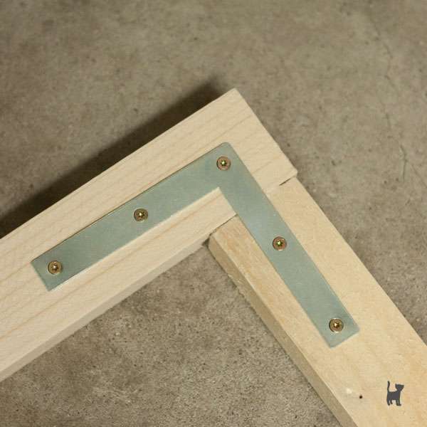 Das Foto zeigt zwei Holzlatten, die im rechten Winkel mit einem Flachwinkel befestigt wurden
