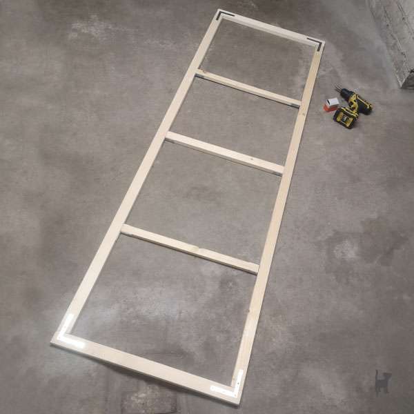 Auf dem Foto liegt die fertig zusammengebaute Gittertür auf dem Boden
